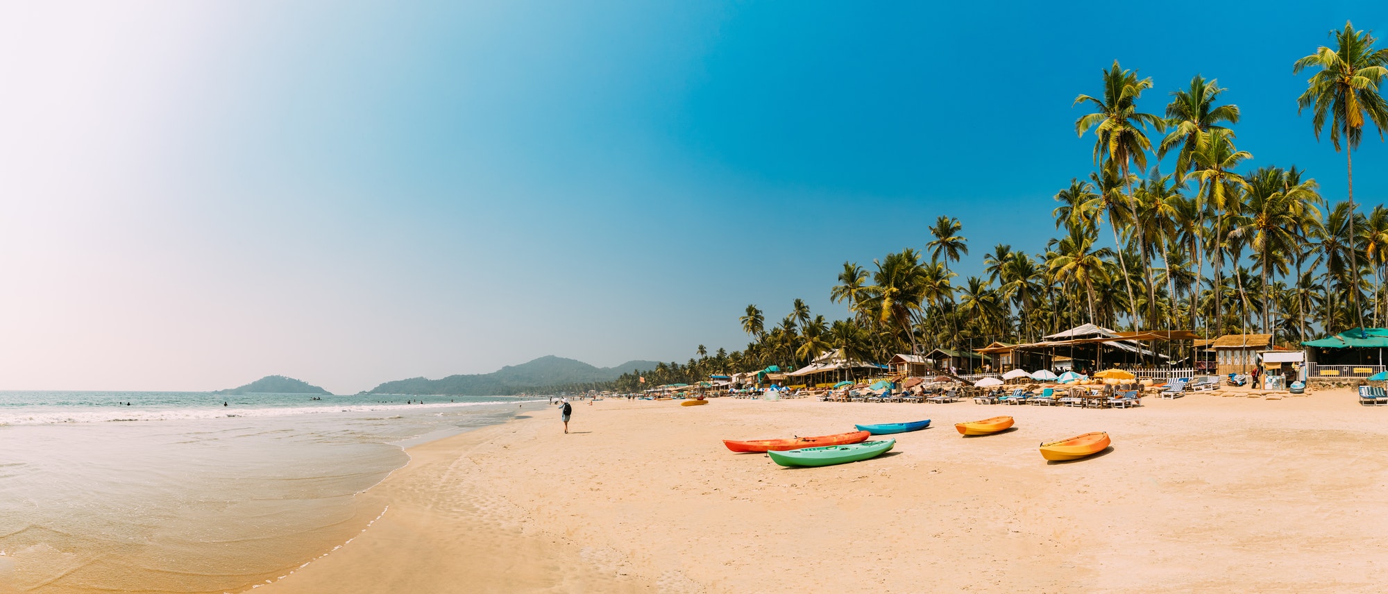 Canacona, Goa, India. Canoe Kayak For Rent Parked On Famous Palolem Beach On Background Tall Palm